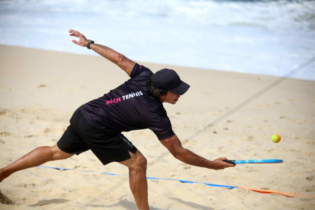 Atleta executando um drop shot numa partida no CT Performance Beach Tennis em Itaipuaçu.