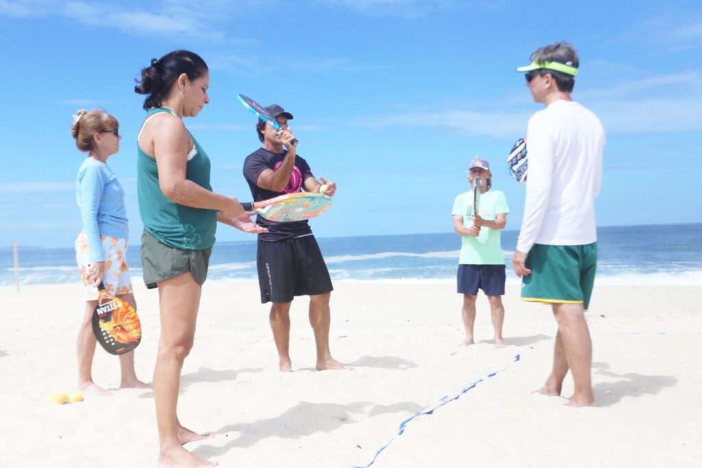 Professor orientando um grupo de 4 alunos durante aula no CT Performance Beach Tennis em Itaipuaçu.