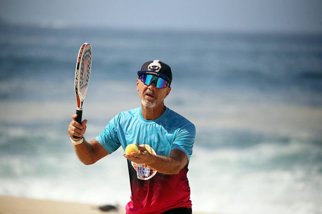 Atleta sacondo num jogo em evento promovido pelo CT Performance Beach Tennis em Itaipuaçu. Foto da galeria de beach tennis em Itaipuaçu.