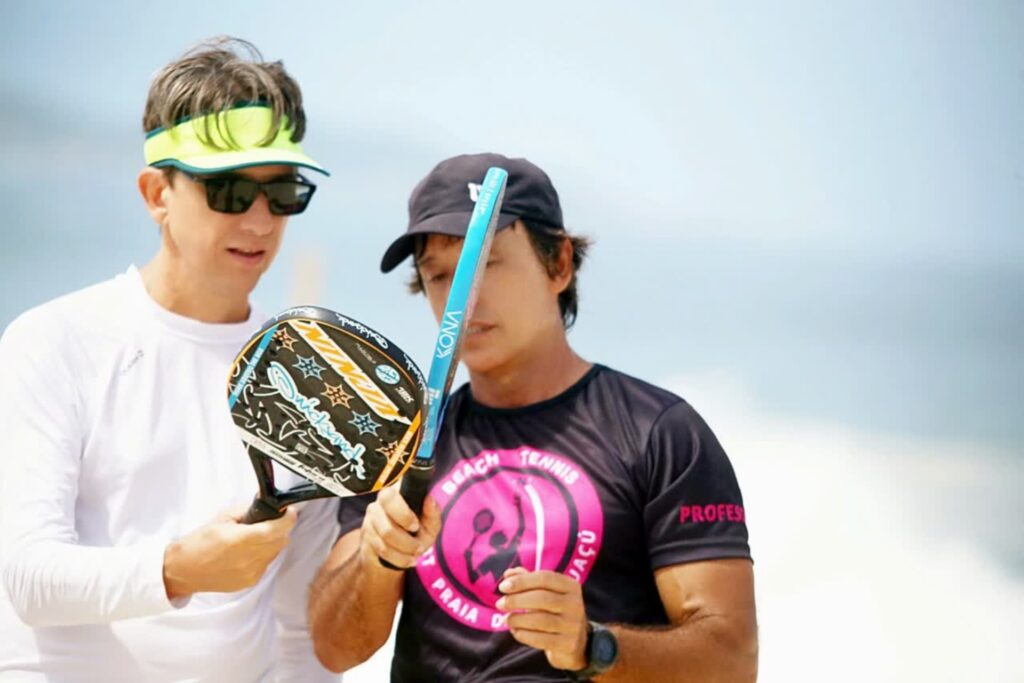 Professor ajustando a empunhadura na raquete do aluno no CT Performance Beach Tennis em Itaipuaçu.